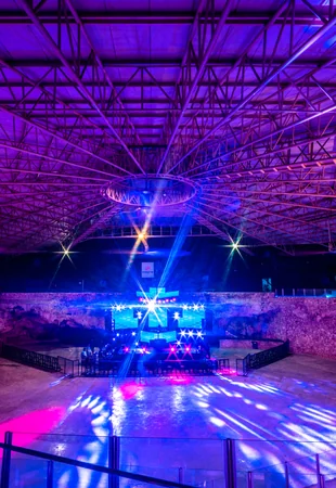 Vista ampla da Imagine Punta Cana com estrutura de teto iluminada, palco principal e telões de LED — palco preparado para evento corporativo