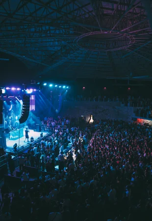 Vista geral do Imagine Punta Cana durante mega show com palco iluminado, luzes azuis e arena lotada de público