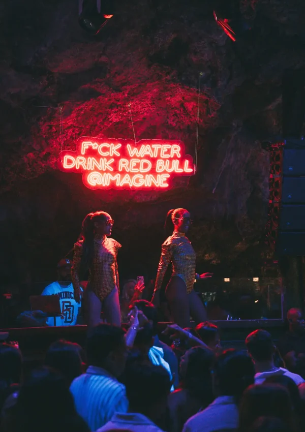 Público em evento privado no Imagine Punta Cana, com mesas e palco iluminados dentro da caverna natural